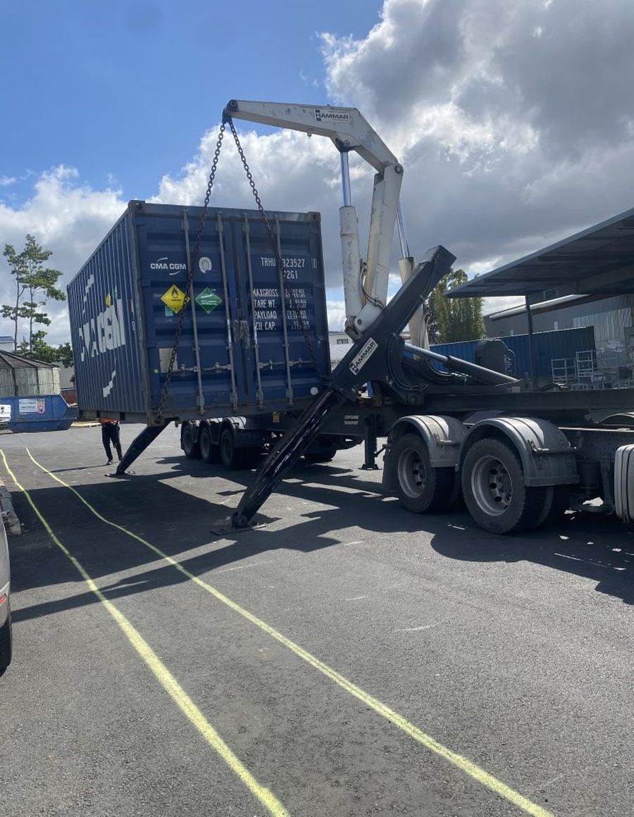 Shipping container being unloaded from a truck